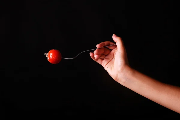 Концепція приготування їжі - жіноча рука з виделкою та помідорами — стокове фото