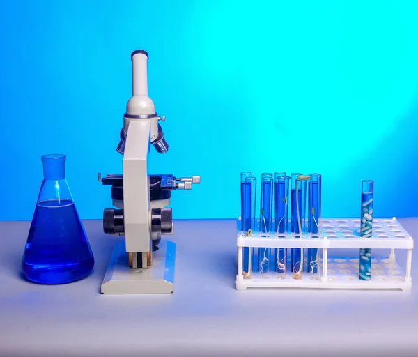 Microscopio metallico da laboratorio e provette con liquido — Foto Stock