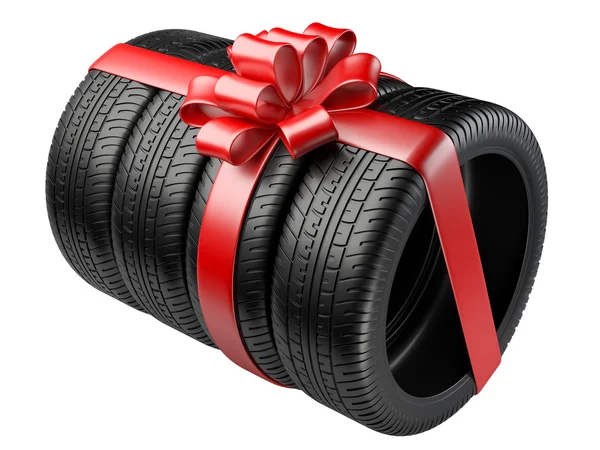 Gift set four tyres with a wrapped red ribbon and bow. — Stock Photo, Image