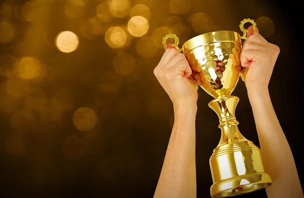 Homem segurando um troféu dourado campeão — Fotografia de Stock