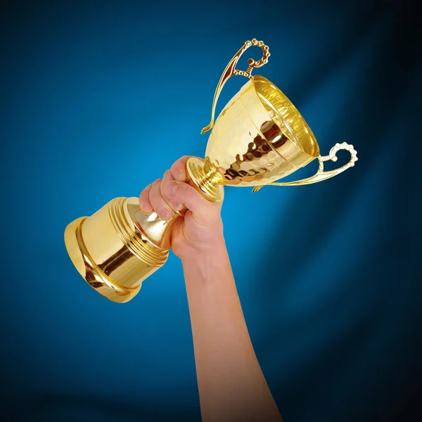 Homem segurando um troféu dourado campeão — Fotografia de Stock