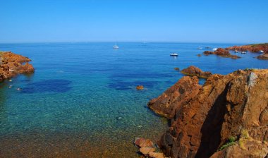 Denizin taşlı manzarası. Koyda berrak mavi su.