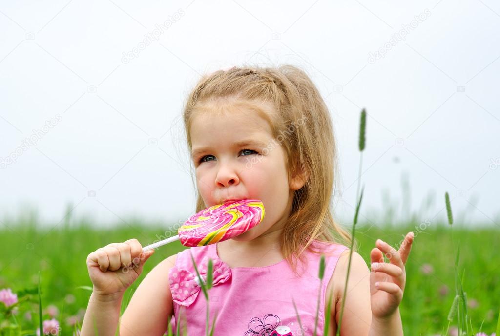  little girl eating a lollipop