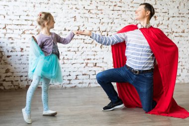 Süper kahraman kostümlü mutlu bir baba ve kızı.