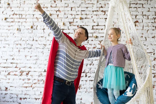 Gelukkige vader in superheld kostuum en zijn dochter — Stockfoto