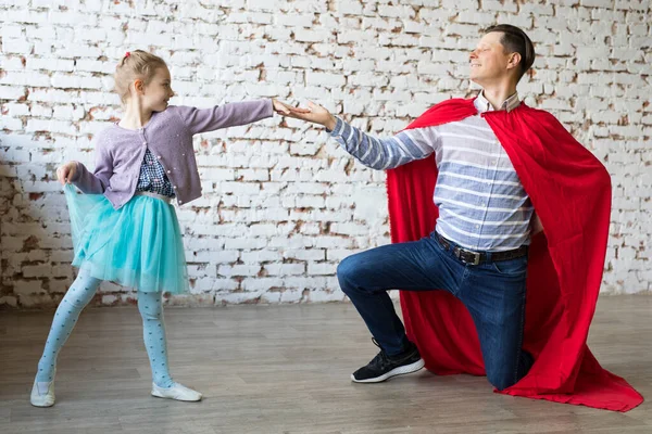 Gelukkige vader in superheld kostuum en zijn dochter — Stockfoto