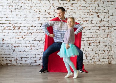 Süper kahraman kostümlü mutlu bir baba ve kızı.