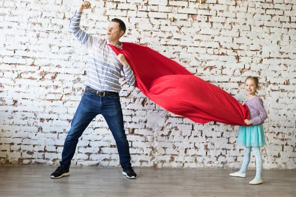 Lycklig far i superhjältedräkt och hans dotter — Stockfoto