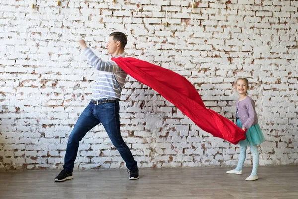 Gelukkige vader in superheld kostuum en zijn dochter — Stockfoto