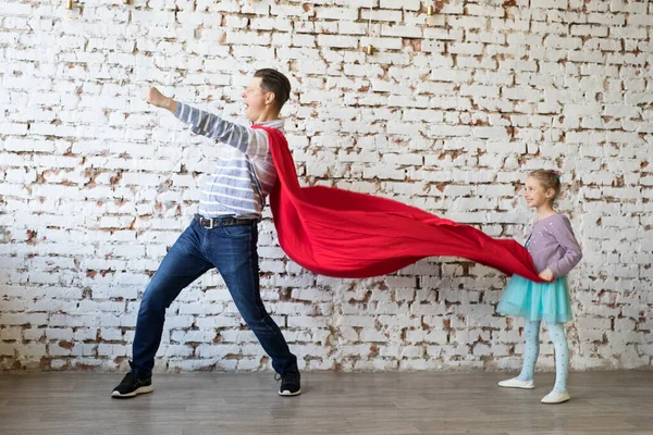 Gelukkige vader in superheld kostuum en zijn dochter — Stockfoto
