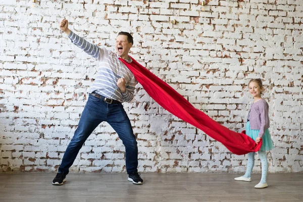 Gelukkige vader in superheld kostuum en zijn dochter — Stockfoto