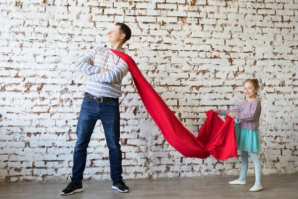 Gelukkige vader in superheld kostuum en zijn dochter — Stockfoto