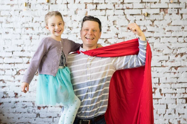 Gelukkige vader in superheld kostuum en zijn dochter — Stockfoto