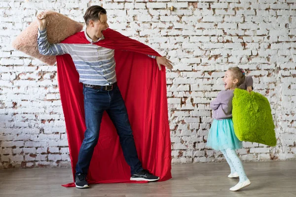 Gelukkige vader in superheld kostuum en zijn dochter — Stockfoto