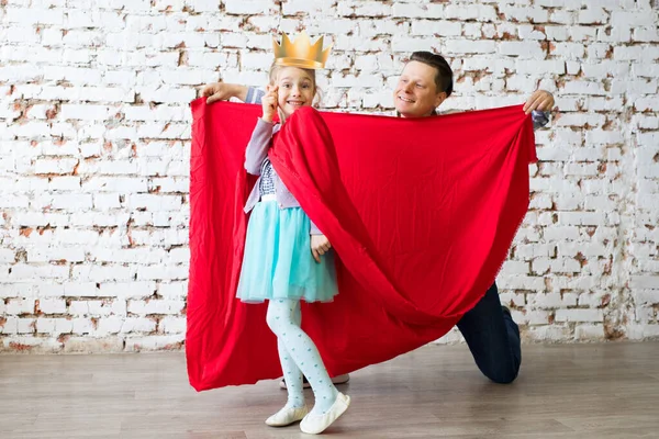 Lycklig far i superhjältedräkt och hans dotter — Stockfoto