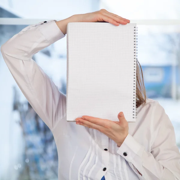 Mulher segurando notebook anel-bound em branco — Fotografia de Stock