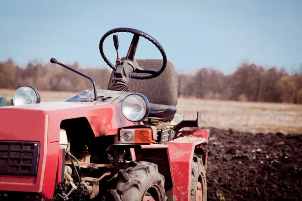 Kis traktor egy mező tavasszal — Stock Fotó