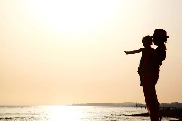 Frau mit Baby bei Sonnenuntergang — Stockfoto