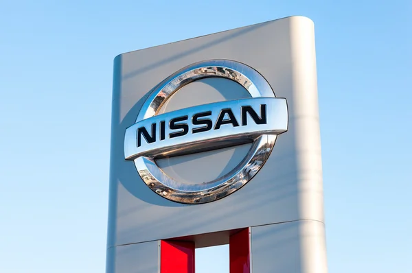 Official dealership sign of Nissan against blue sky — Stock Photo, Image