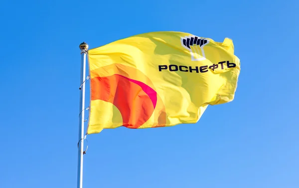 Le drapeau de la compagnie pétrolière Rosneft contre le ciel bleu — Photo