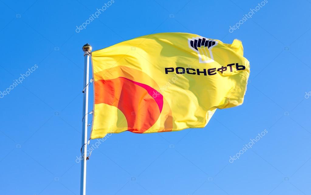 SAMARA, RUSSIA - FEBRUARY 20, 2016: The flag of oil company Rosneft against blue sky. Rosneft is one of the largest russian oil companies
