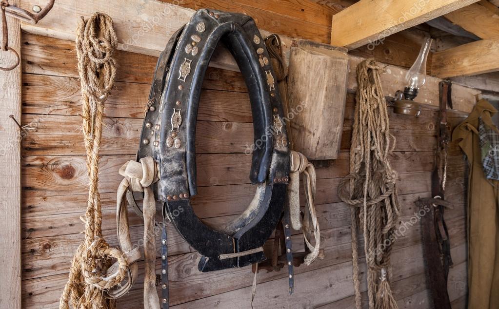 Old horse collar hanging on wall of a wooden home — Stock Photo