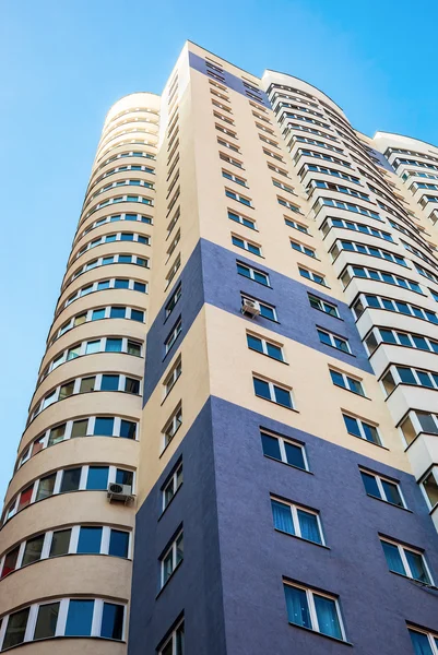 Mavi gökyüzü arka plan karşı yeni uzun boylu apartman — Stok fotoğraf