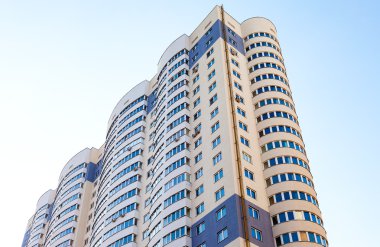 Mavi gökyüzü arka plan karşı yeni uzun boylu apartman