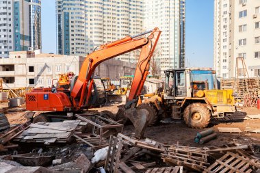 Yapım aşamasında bir apartman binaları yakınındaki inşaat makine standları