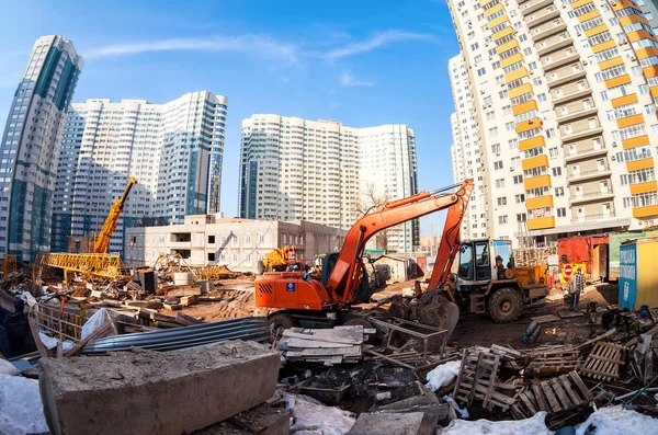 Baumaschinen stehen in der Nähe eines im Bau befindlichen Mehrfamilienhauses — Stockfoto