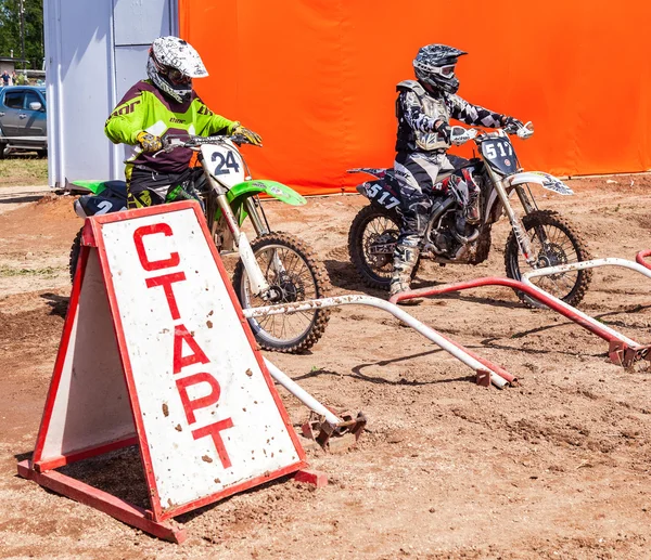 Motocrossers in the starting line waiting for race to start — Stock Photo, Image