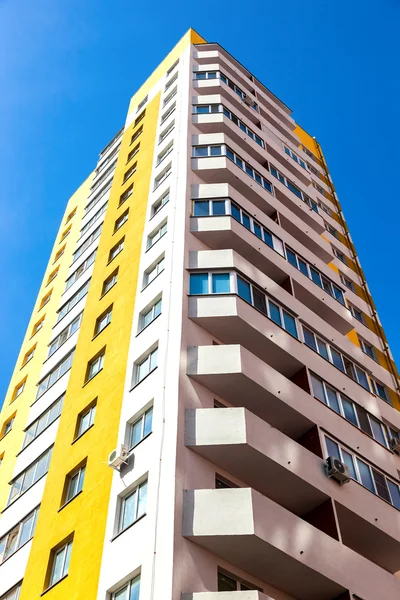 Mavi gökyüzü arka plan karşı yeni uzun boylu apartman