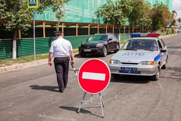 Russischer Polizist und an der Straße geparktes Streifenfahrzeug — Stockfoto