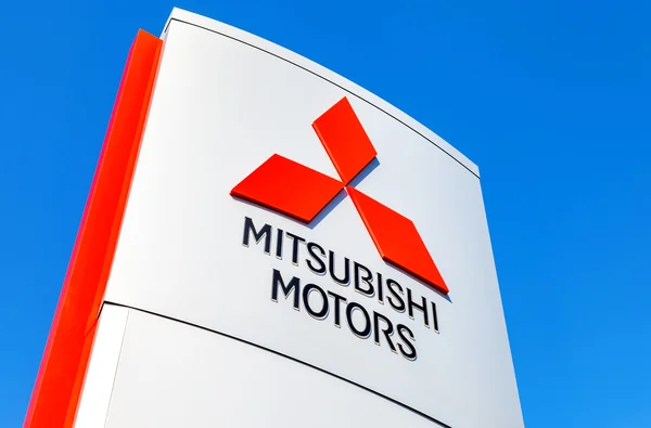 Official dealership sign of Mitsubishi against the blue sky — Stock Photo, Image