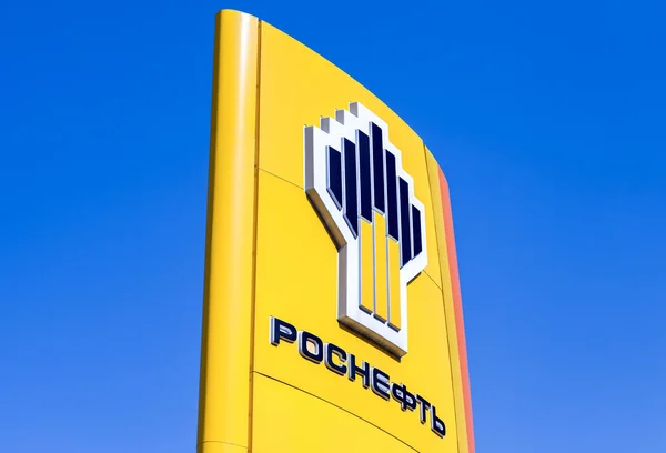 O emblema da companhia petrolífera Rosneft contra o céu azul backg — Fotografia de Stock