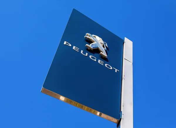 Signe officiel de concession de Peugeot contre le fond bleu du ciel — Photo