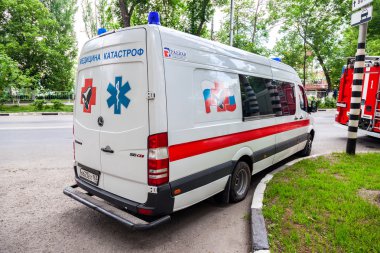 Ambulans araba sokakta park edilmiş. Metin Rusça: 