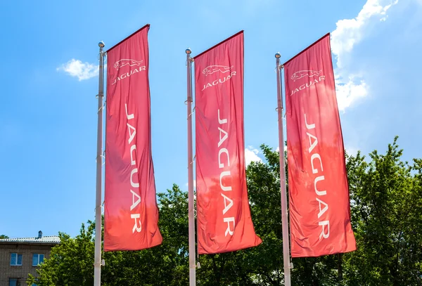Official dealership flags of Jaguar against the blue sky background