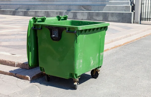 Recipiente de reciclagem de plástico verde aberto na ensolarada árvore da cidade — Fotografia de Stock