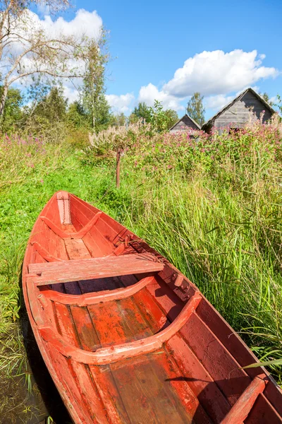 Old red wooden fishing boat at the lake in summer day — Stock Photo, Image