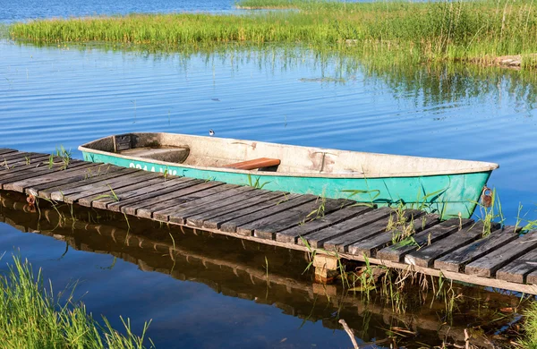 Fiske båt förtöjd vid en brygga vid sjön på morgonen i summ — Stockfoto