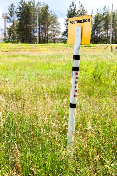 Señal de advertencia en un campo donde el cable de comunicación Rostelekom. Te... —  Fotos de Stock