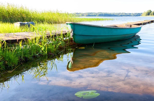 Rybářské lodi zakotvené na molo na jezeře ráno v summ — Stock fotografie