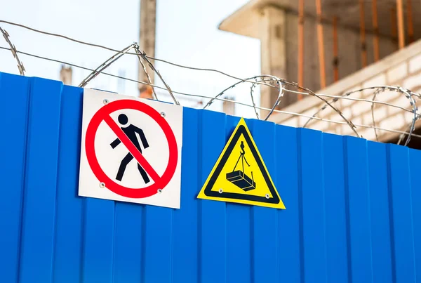 Warning signs and barbed wire on the fence at the construction s — Stock Photo, Image