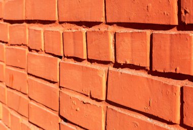 Arka plan olarak eski yıpranmış kırmızı tuğla duvar. Duvarları dikişli tuğlalar. Açıdan görüntüle