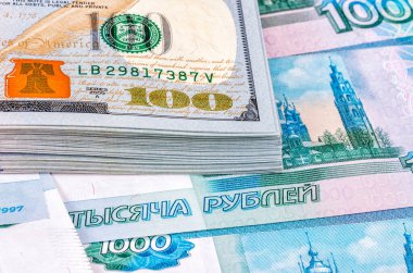 Rus rublesi üzerinden 100 Amerikan doları yığını, yakın çekim.