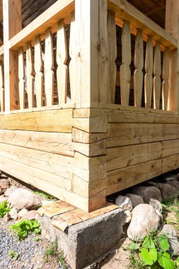 Tahta evin köşesinde, destek taşı temelinde.