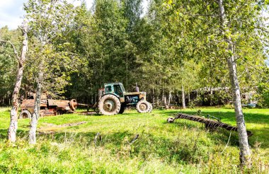 Tekerlekli traktörü ve diğer ekipmanları olan eski toprak tarım makineleri
