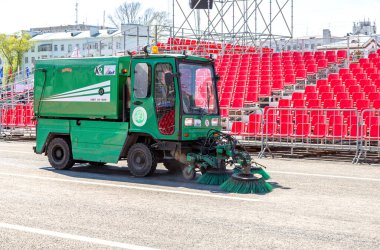 Samara, Russia - May 1, 2019: Street sweeper machine cleans street with brushes and water clipart
