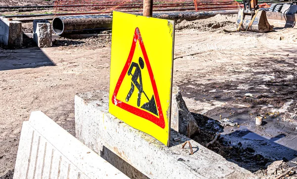 Road sign. Road repair in city street in summer. City street construction site with barricades, safety fence net. Road work